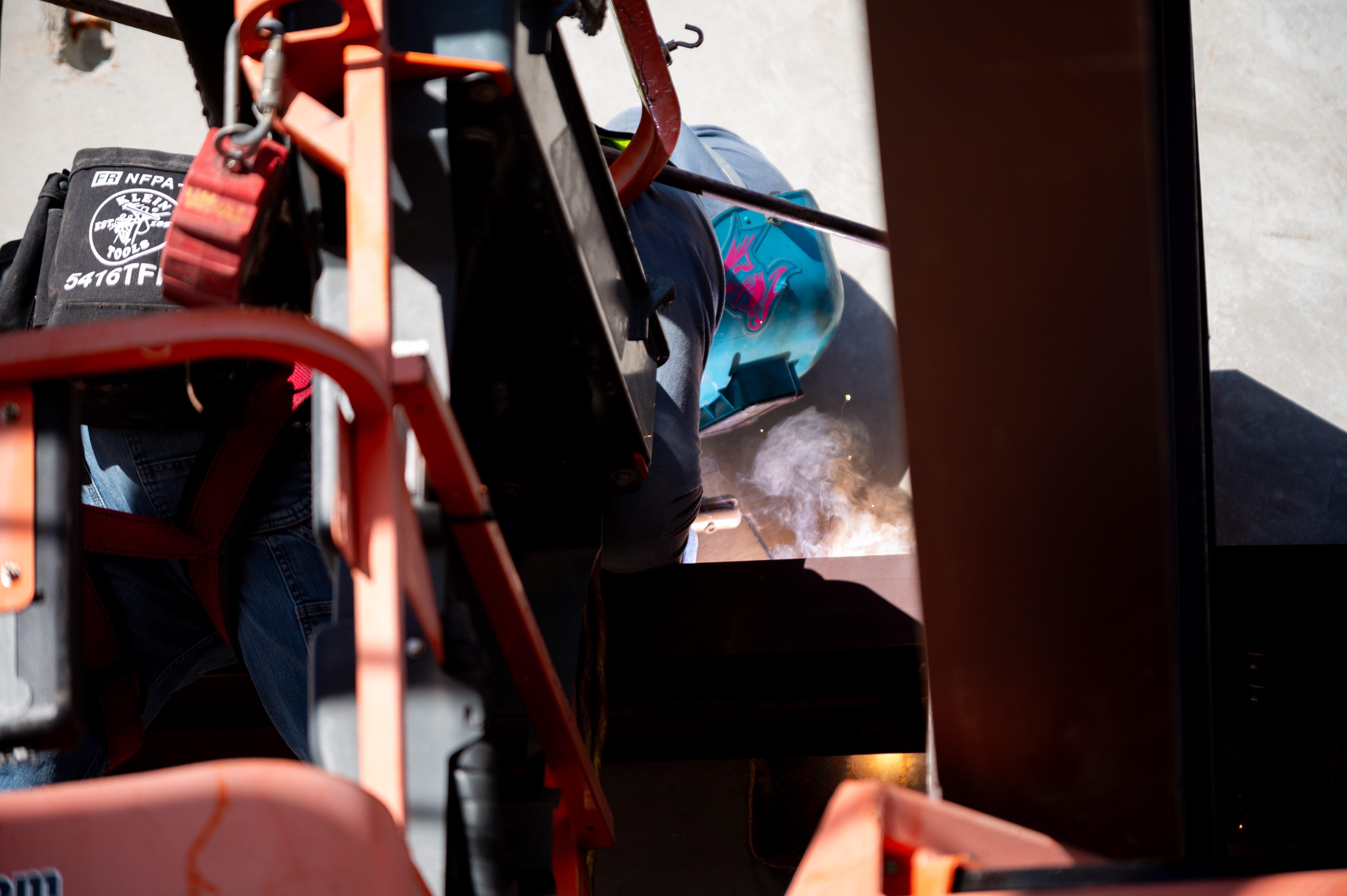 Welder cutting and welding steel plate on site
