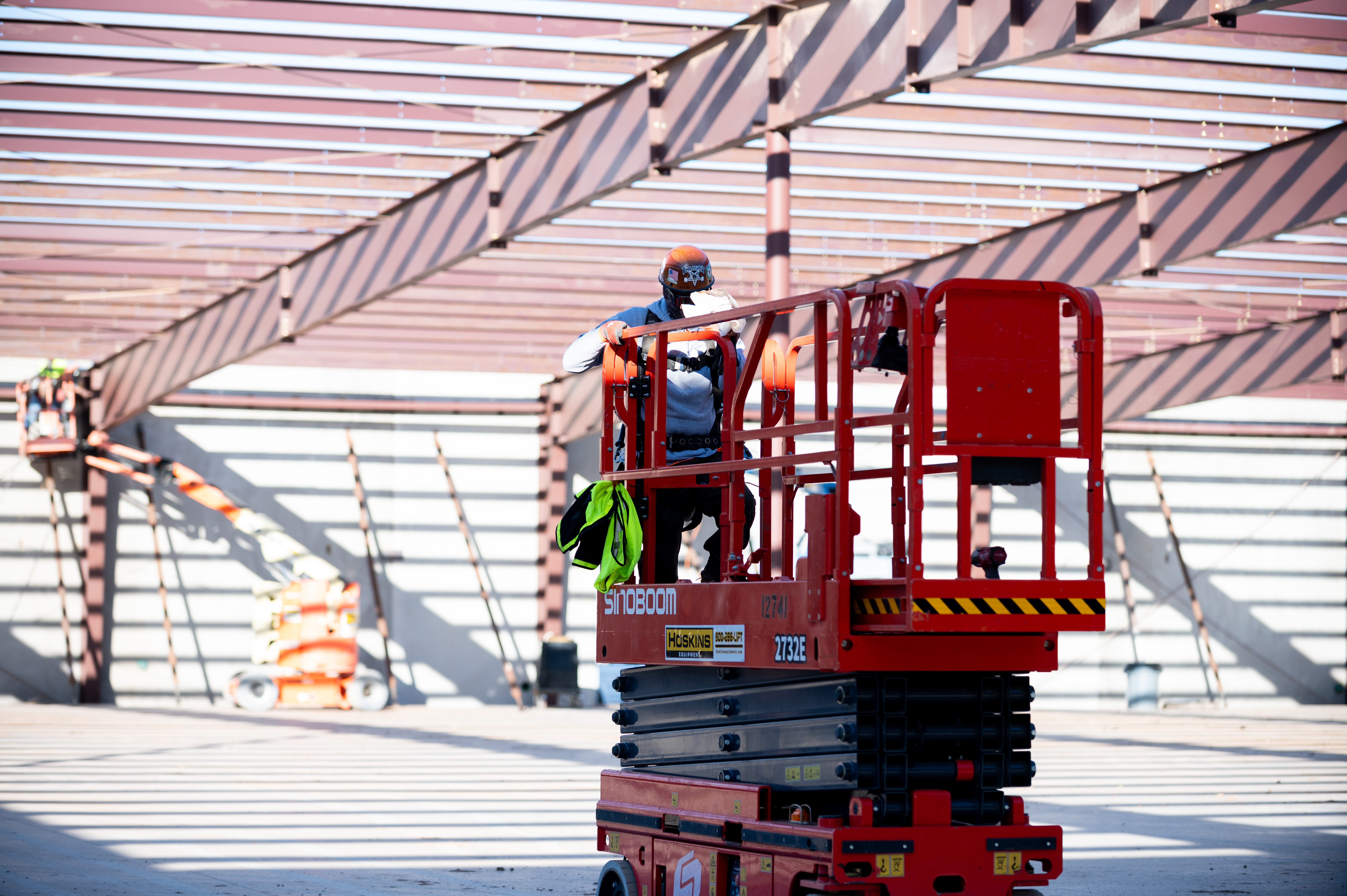 Crew member on a lift under tube and structural framing